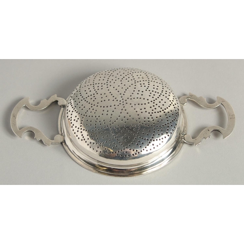 1894 - A GEORGE II SILVER TWO HANDLED CIRCULAR LEMON STRAINER. 3.75ins diameter.  London 1755.  Maker James... 