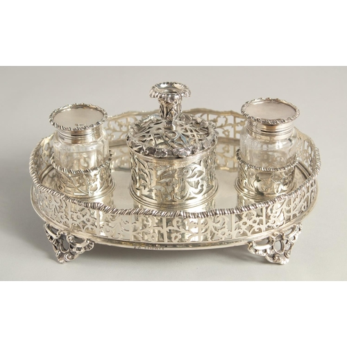 1897 - A SUPERB VICTORIAN SILVER OVAL INKSTAND with pierced gallery, two glass top bottles and silver toppe... 