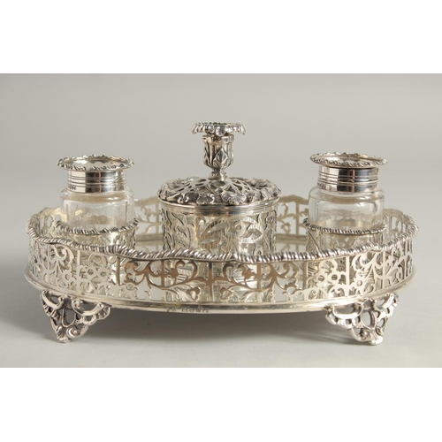 1897 - A SUPERB VICTORIAN SILVER OVAL INKSTAND with pierced gallery, two glass top bottles and silver toppe... 