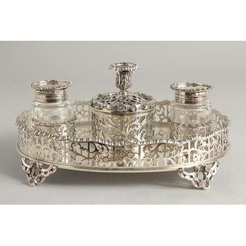 1897 - A SUPERB VICTORIAN SILVER OVAL INKSTAND with pierced gallery, two glass top bottles and silver toppe... 