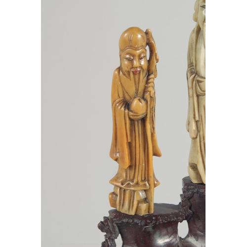 20 - TWO CHINESE SOAPSTONE CARVINGS, one carved with foo dogs, the other of immortals on a soapstone base... 