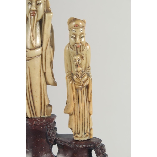 20 - TWO CHINESE SOAPSTONE CARVINGS, one carved with foo dogs, the other of immortals on a soapstone base... 