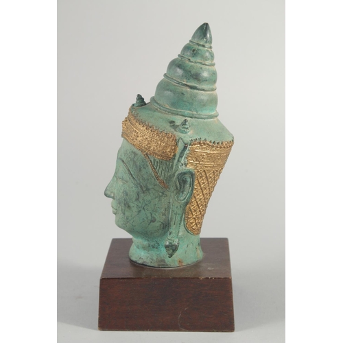25 - A THAI METAL BUDDHA HEAD, with gilded headpiece and mounted to a wooden base, head 22cm high.