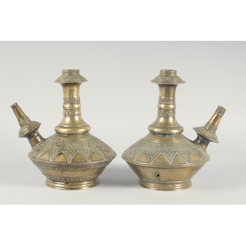 38 - A PAIR OF EARLY ISLAMIC BRASS HUQQA BASES, with bands of foliate decoration, 25cm high.