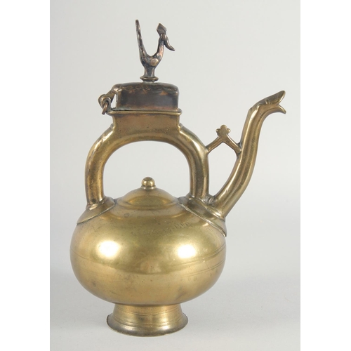 39 - AN ISLAMIC BRONZE EWER, the handle with peacock finial, inscribed, 31cm high.