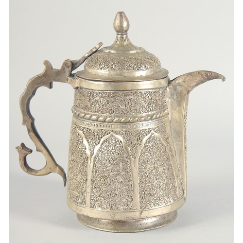40 - AN ISLAMIC WHITE METAL LIDDED JUG, embossed and chased decoration, 25cm high.