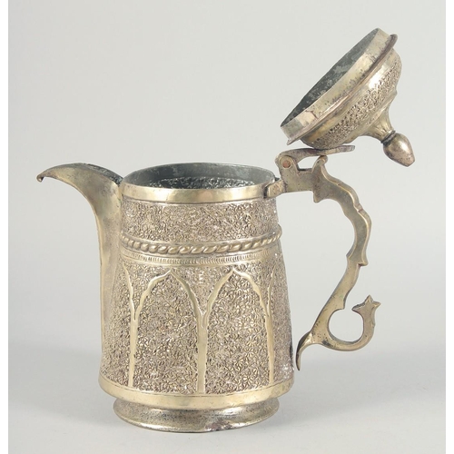 40 - AN ISLAMIC WHITE METAL LIDDED JUG, embossed and chased decoration, 25cm high.
