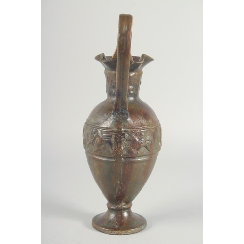41 - AN EARLY CLASSICAL BRONZE EWER, with a band of archaic style figures to the body, 35cm high.