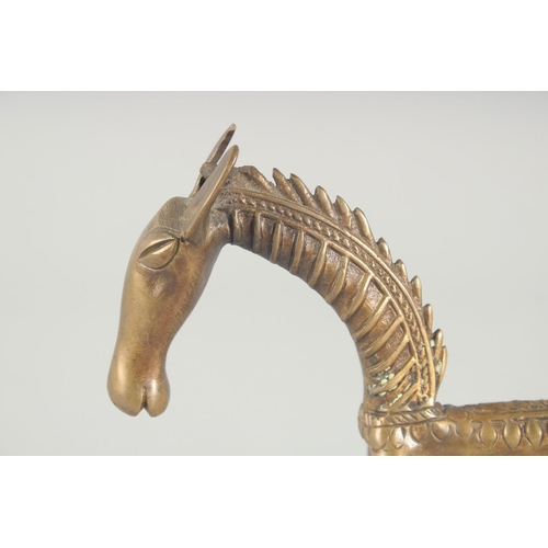 42 - AN ISLAMIC BRASS FIGURE OF A STYLISED HORSE, 24.5cm long.