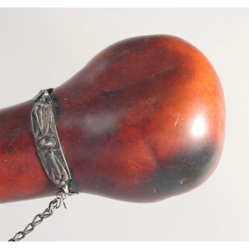 60 - A SMALL POWDER FLASK, with metal mounts, possibly a type of nut, 16cm long.