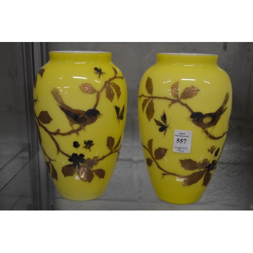 557 - A pair of yellow opaque glass vases, gilt decorated with birds on branches.