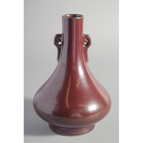 132 - A CHINESE OX BLOOD GLAZE TWIN HANDLE VASE, six-character mark to base, 22.5cm high.