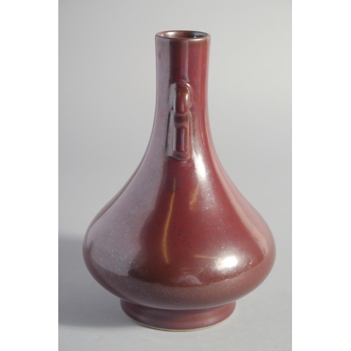 132 - A CHINESE OX BLOOD GLAZE TWIN HANDLE VASE, six-character mark to base, 22.5cm high.