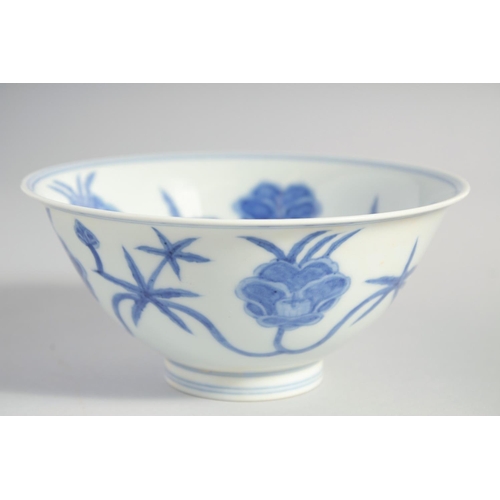 157 - A CHINESE BLUE AND WHITE MING STYLE BOWL, the interior and exterior painted with flower heads, base ... 