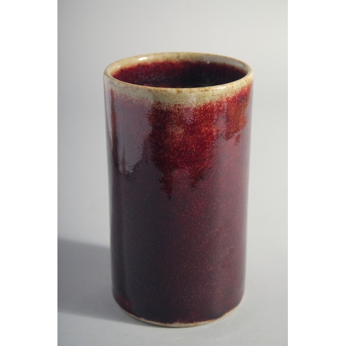 164 - A CHINESE IRON RED GLAZE CYLINDRICAL BRUSH POT, 15cm high.