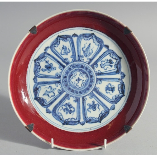 176 - A CHINESE BLUE, WHITE AND COPPER RED DISH, decorated with radiating medallion to the centre, inscrib... 