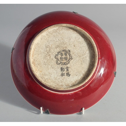 176 - A CHINESE BLUE, WHITE AND COPPER RED DISH, decorated with radiating medallion to the centre, inscrib... 