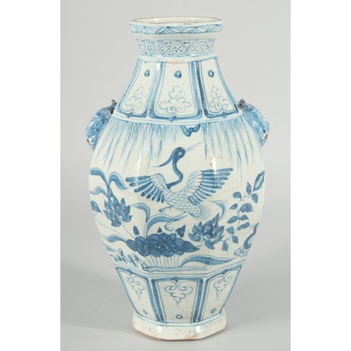 185 - A CHINESE OCTAGONAL BLUE AND WHITE TWIN HANDLE VASE, with moulded lion heads as handles, the body pa... 