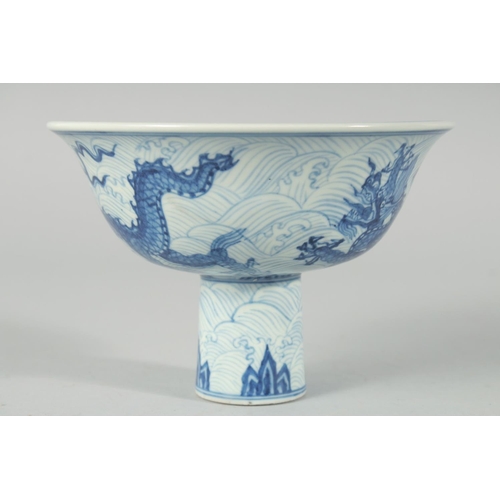 192 - A CHINESE BLUE AND WHITE PORCELAIN STEM CUP, decorated with dragons on a wave-pattern ground, interi... 