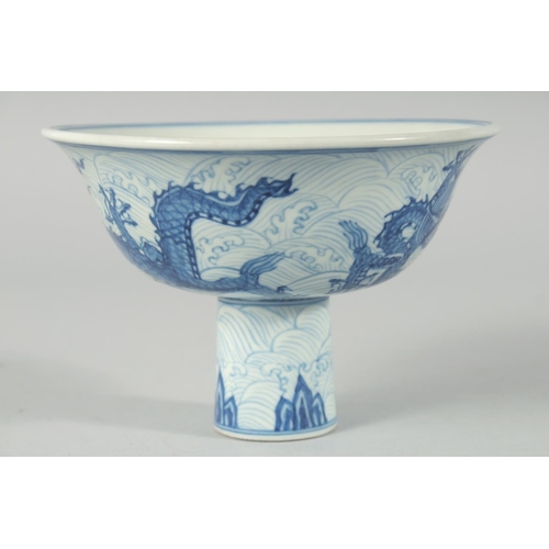 192 - A CHINESE BLUE AND WHITE PORCELAIN STEM CUP, decorated with dragons on a wave-pattern ground, interi... 