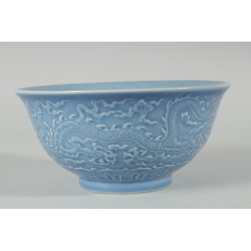 193 - A CHINESE POWDER BLUE GLAZE PORCELAIN BOWL, the exterior with carved dragon, six-character mark to b... 