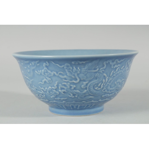 193 - A CHINESE POWDER BLUE GLAZE PORCELAIN BOWL, the exterior with carved dragon, six-character mark to b... 