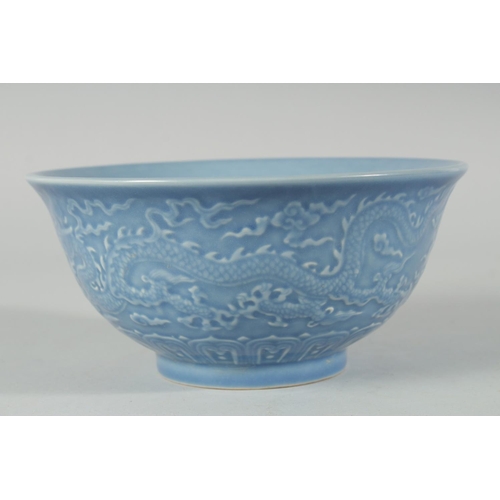 193 - A CHINESE POWDER BLUE GLAZE PORCELAIN BOWL, the exterior with carved dragon, six-character mark to b... 