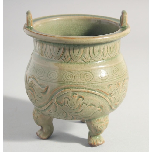 212 - A CHINESE LONGQUAN CELADON TRIPOD CENSER, with carved foliate decoration, 15.5cm high.