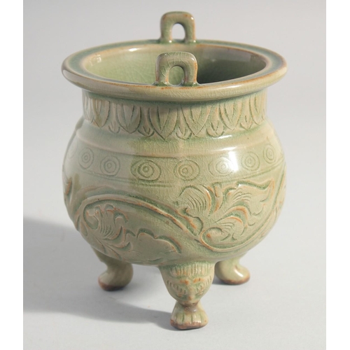 212 - A CHINESE LONGQUAN CELADON TRIPOD CENSER, with carved foliate decoration, 15.5cm high.