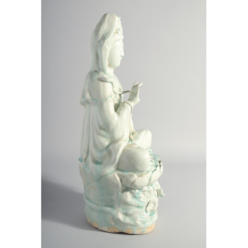 219 - A LARGE CHINESE YINGQING GLAZE QUANYIN seated upon a lotus throne, 45cm high.