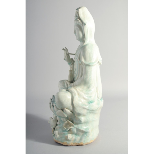 219 - A LARGE CHINESE YINGQING GLAZE QUANYIN seated upon a lotus throne, 45cm high.