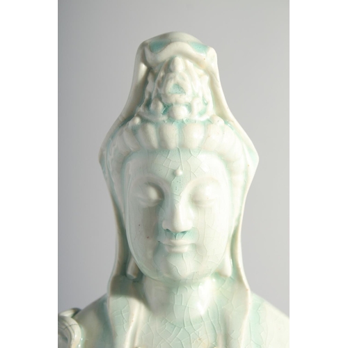 219 - A LARGE CHINESE YINGQING GLAZE QUANYIN seated upon a lotus throne, 45cm high.