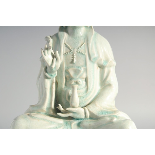 219 - A LARGE CHINESE YINGQING GLAZE QUANYIN seated upon a lotus throne, 45cm high.