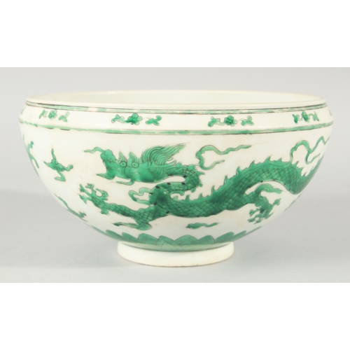 225 - A CHINESE GREEN ENAMELLED PORCELAIN BOWL, decorated with dragons and clouds, 24.5cm diameter.