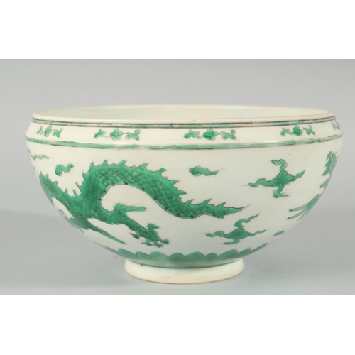 225 - A CHINESE GREEN ENAMELLED PORCELAIN BOWL, decorated with dragons and clouds, 24.5cm diameter.