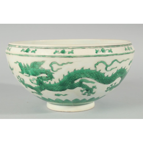 225 - A CHINESE GREEN ENAMELLED PORCELAIN BOWL, decorated with dragons and clouds, 24.5cm diameter.