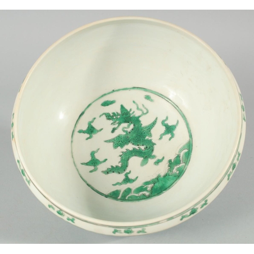 225 - A CHINESE GREEN ENAMELLED PORCELAIN BOWL, decorated with dragons and clouds, 24.5cm diameter.