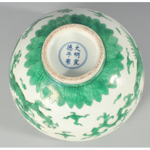 225 - A CHINESE GREEN ENAMELLED PORCELAIN BOWL, decorated with dragons and clouds, 24.5cm diameter.