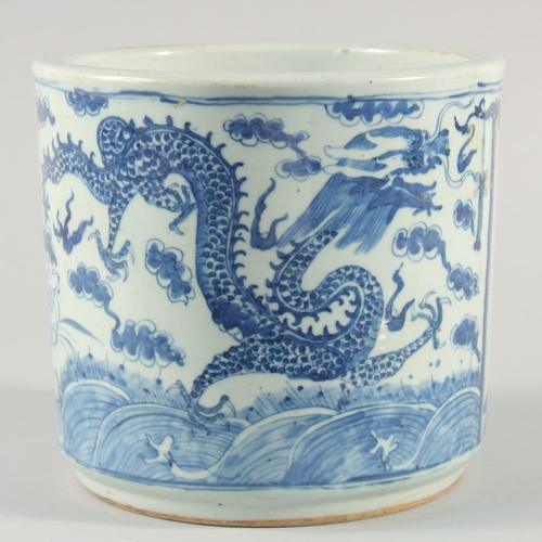 234 - A LARGE CHINESE BLUE AND WHITE PORCELAIN BRUSH POT, decorated with dragons above stylised waves incl... 