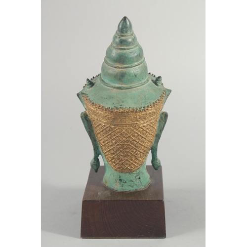 239 - A THAI METAL BUDDHA HEAD, with gilded headpiece and mounted to a wooden base, head 22cm high.