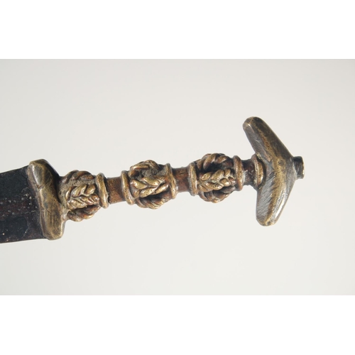 260 - AN UNUSUAL 19TH CENTURY OR EARLIER AFRICAN BRASS HILTED DAGGER, 24cm long.