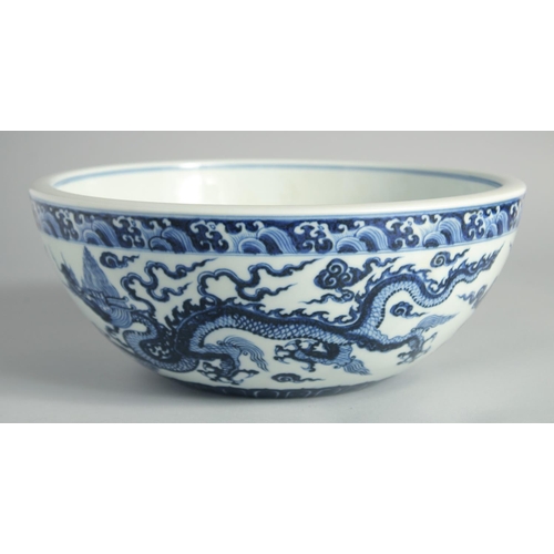 103 - A LARGE CHINESE BLUE AND WHITE PORCELAIN DRAGON BOWL, the dragons amongst stylised clouds beneath a ... 