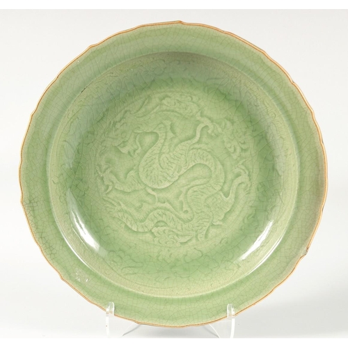 104 - A CHINESE LONGQUAN PETAL FORM CELADON CHARGER, with carved dragon to the centre, 41cm diameter.