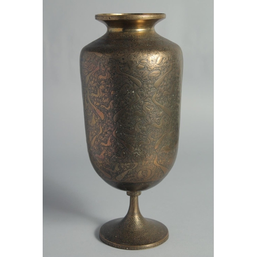 12 - A TALL ISLAMIC ENGRAVED BRASS PEDESTAL VASE, the engraved and chased decoration depicting deities an... 