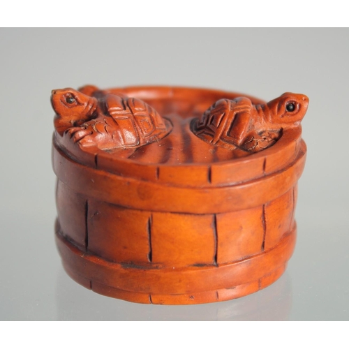 122 - A JAPANESE BOXWOOD NETSUKE OF TORTOISES in a barrel.