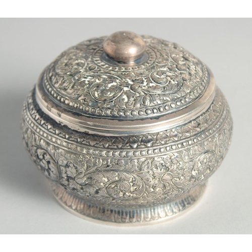 15 - AN CAMBODIAN SILVER CIRCULAR LIDDED BOX, with embossed and engraved foliate decoration, stamped to b... 