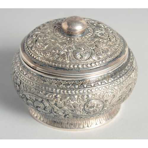 15 - AN CAMBODIAN SILVER CIRCULAR LIDDED BOX, with embossed and engraved foliate decoration, stamped to b... 