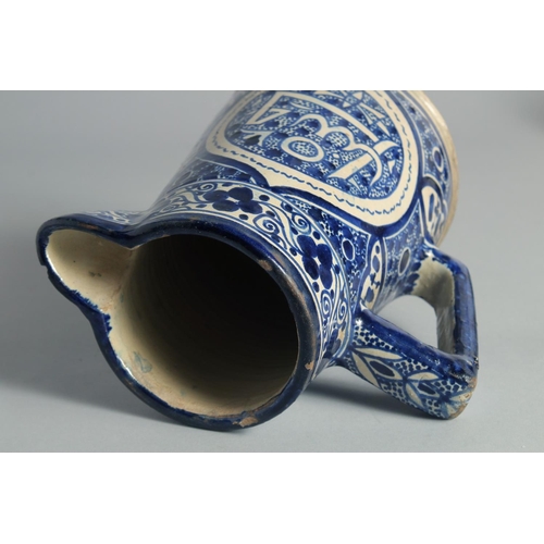 20 - AN ISLAMIC BLUE AND WHITE GLAZED POTTERY EWER, 20.5cm high.