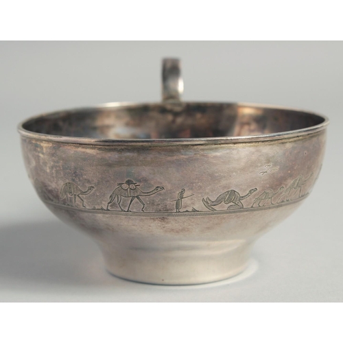 328 - A LARGE IRAQI SILVER CUP AND SAUCER, with engraved decoration of camels and boats, weight 220g, (2 p... 