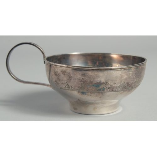 328 - A LARGE IRAQI SILVER CUP AND SAUCER, with engraved decoration of camels and boats, weight 220g, (2 p... 